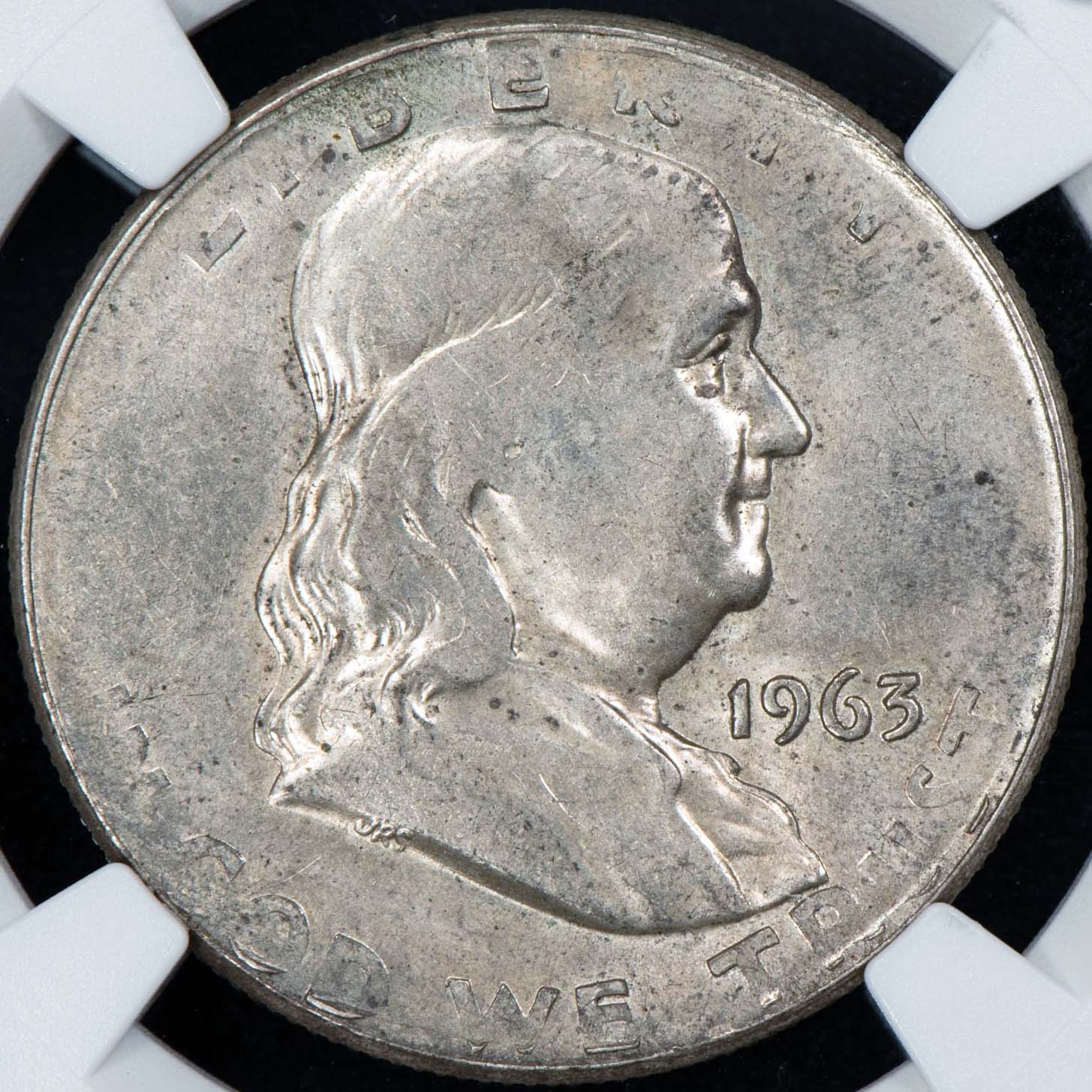 1963-D Franklin half dollar wrong planchet error — undersized coin struck on dime planchet shown next to a normal half dollar for scale